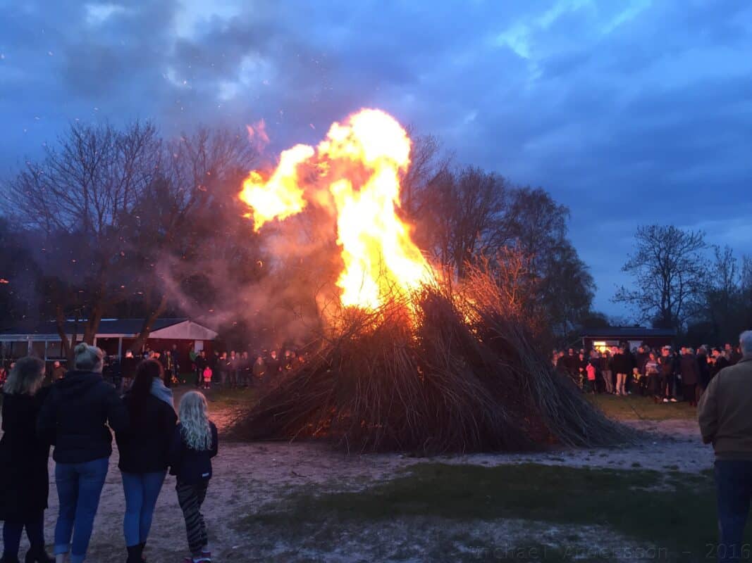 rear-view-people-standing-by-bonfire - AktivitetsHyra